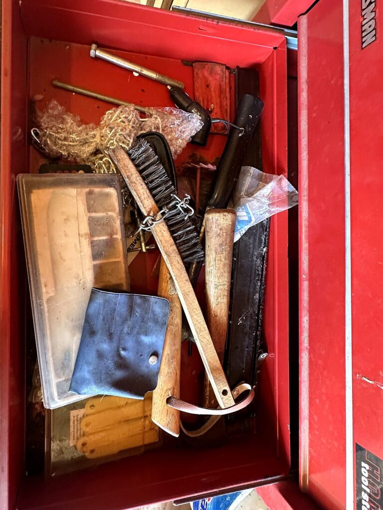Tool chest drawer with wire brushes and hand tools