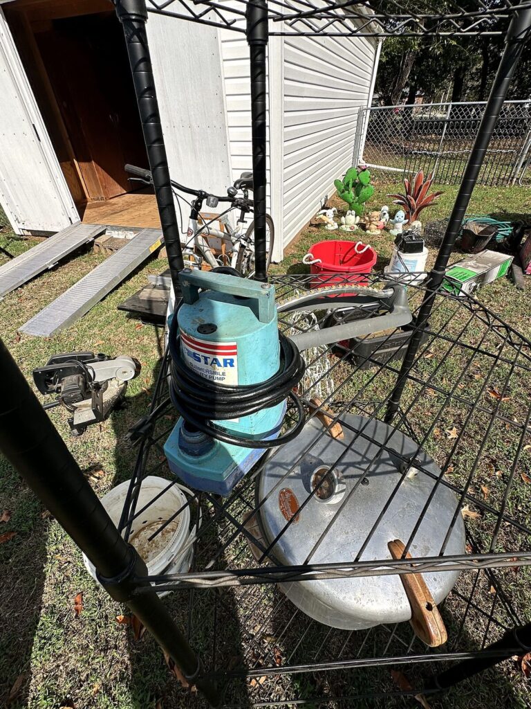 Black wire shelving, utility pump, aluminum pressure canner and jumper cables