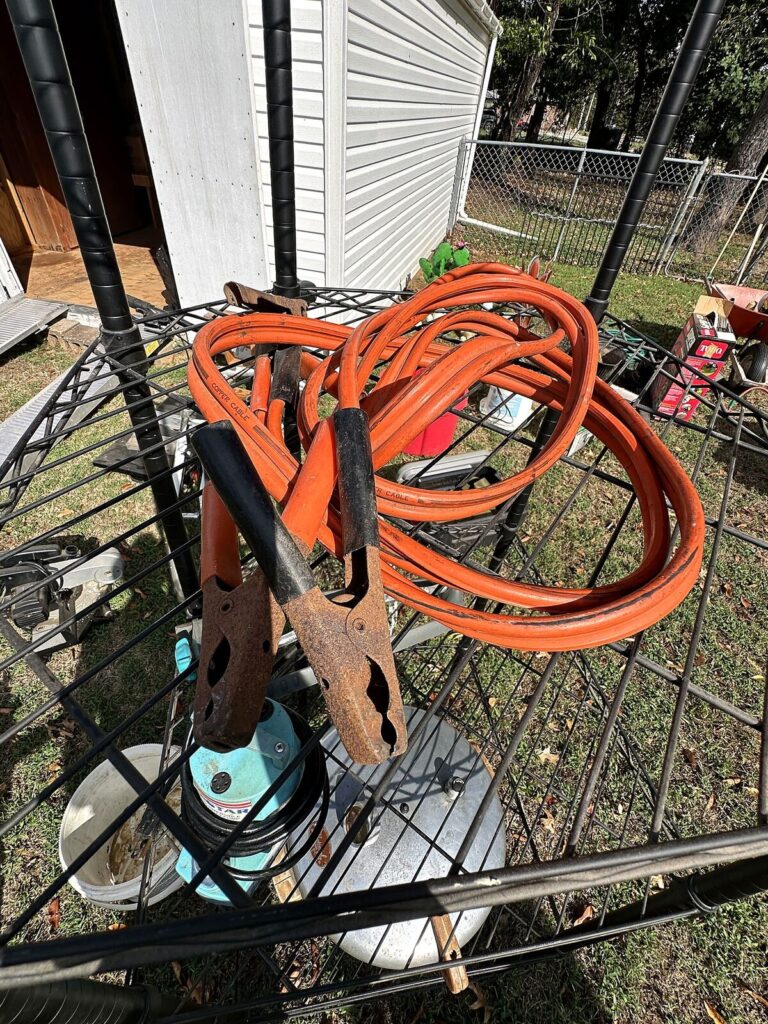 Black wire shelving, utility pump, aluminum pressure canner and jumper cables
