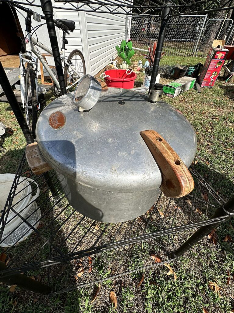 Black wire shelving, utility pump, aluminum pressure canner and jumper cables
