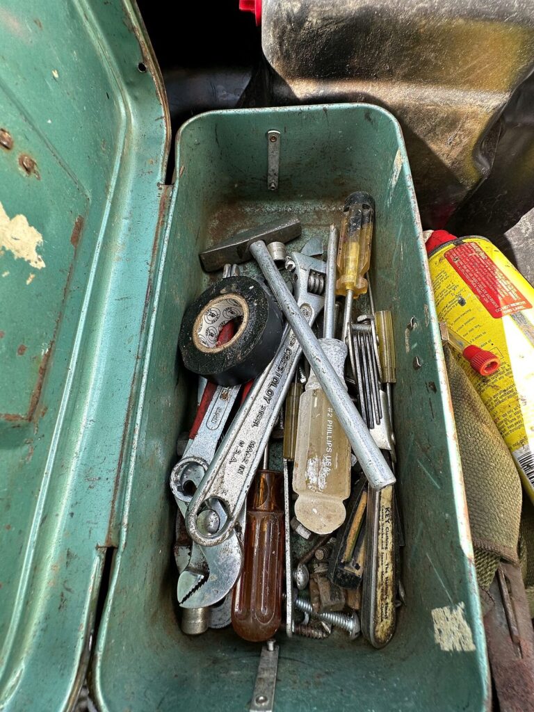 Green metal toolbox with wrenches and screwdrivers