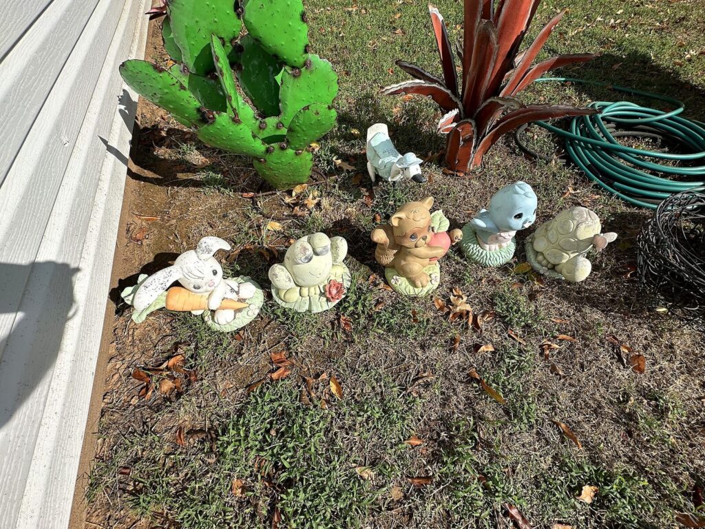 Metal prickly pear cactus and agave yard art with concrete yard animals