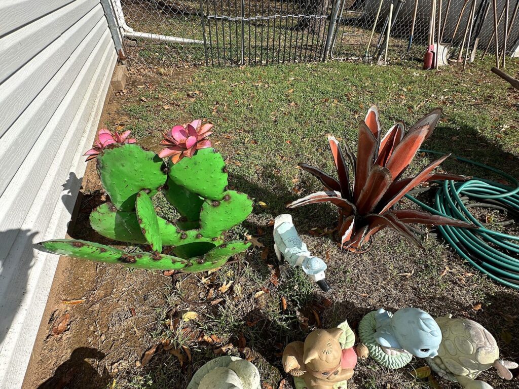 Metal prickly pear cactus and agave yard art with concrete yard animals