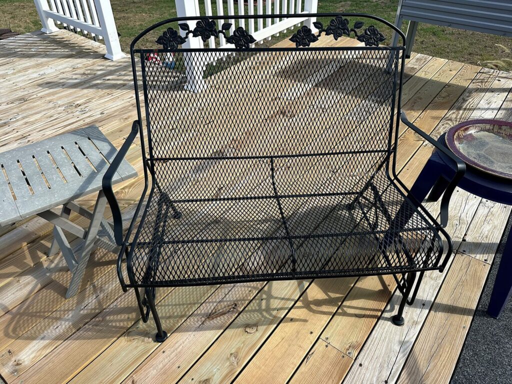 Black wrought-iron mesh loveseat