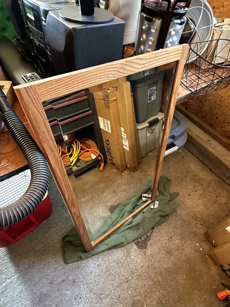 Oak-framed wall mirror, extension cords and storage totes