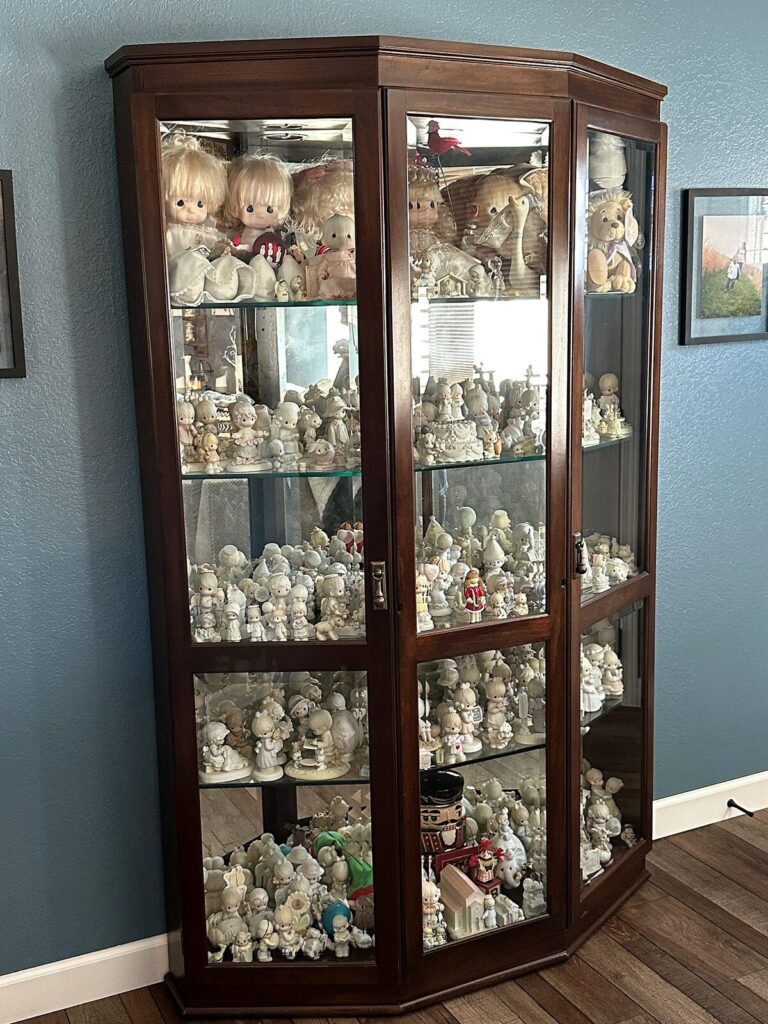 Lighted curio cabinet full of Precious Moments figurines