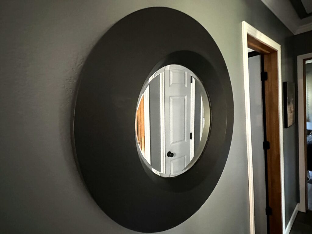 Round black-framed wall mirror