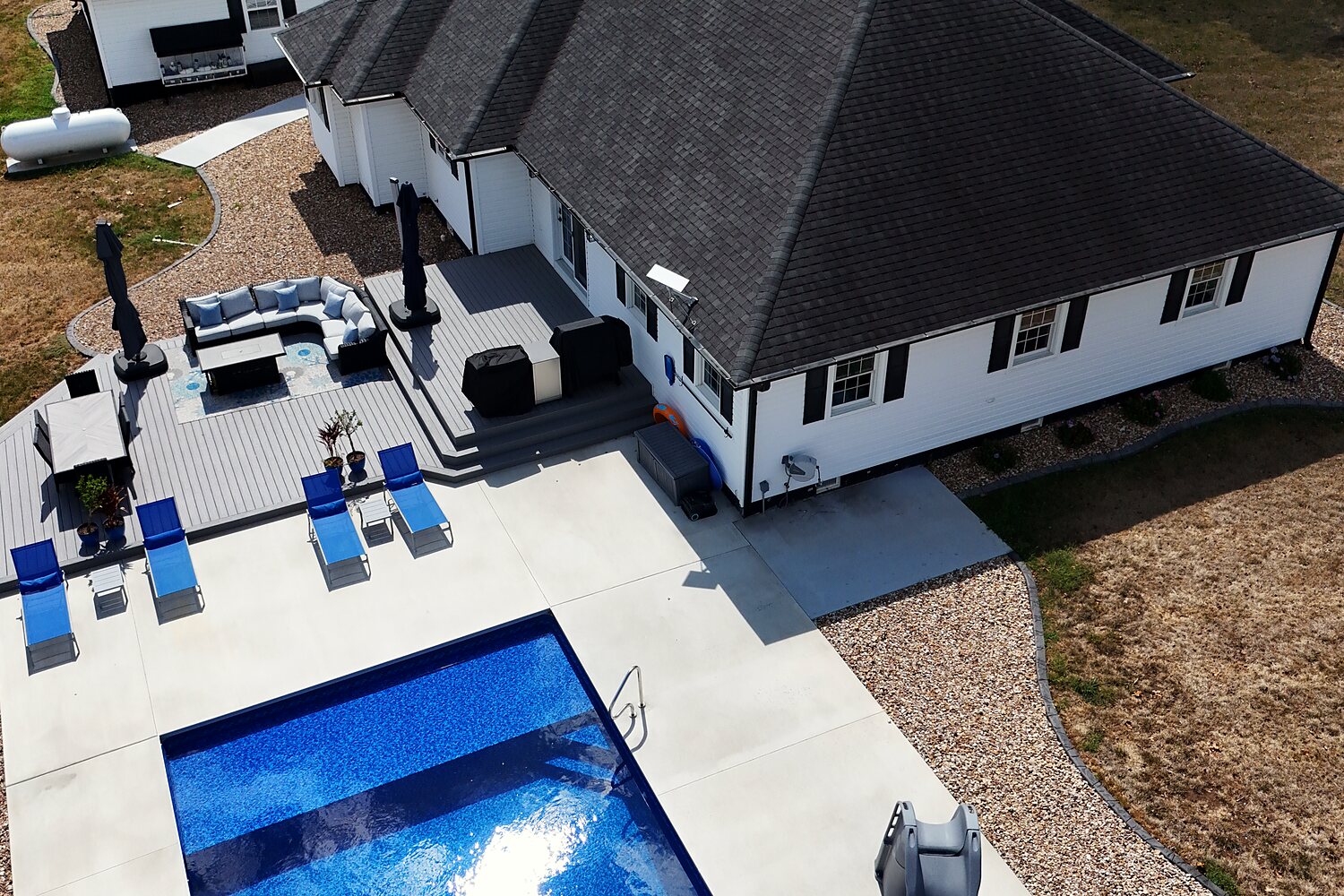 Aerial drone photo of a Curtis and Sons listing with pool and deck, Nevada, Missouri